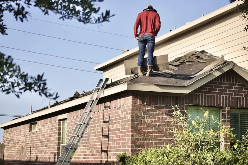 Professional roofer working on a residential roof in Carroll Manor